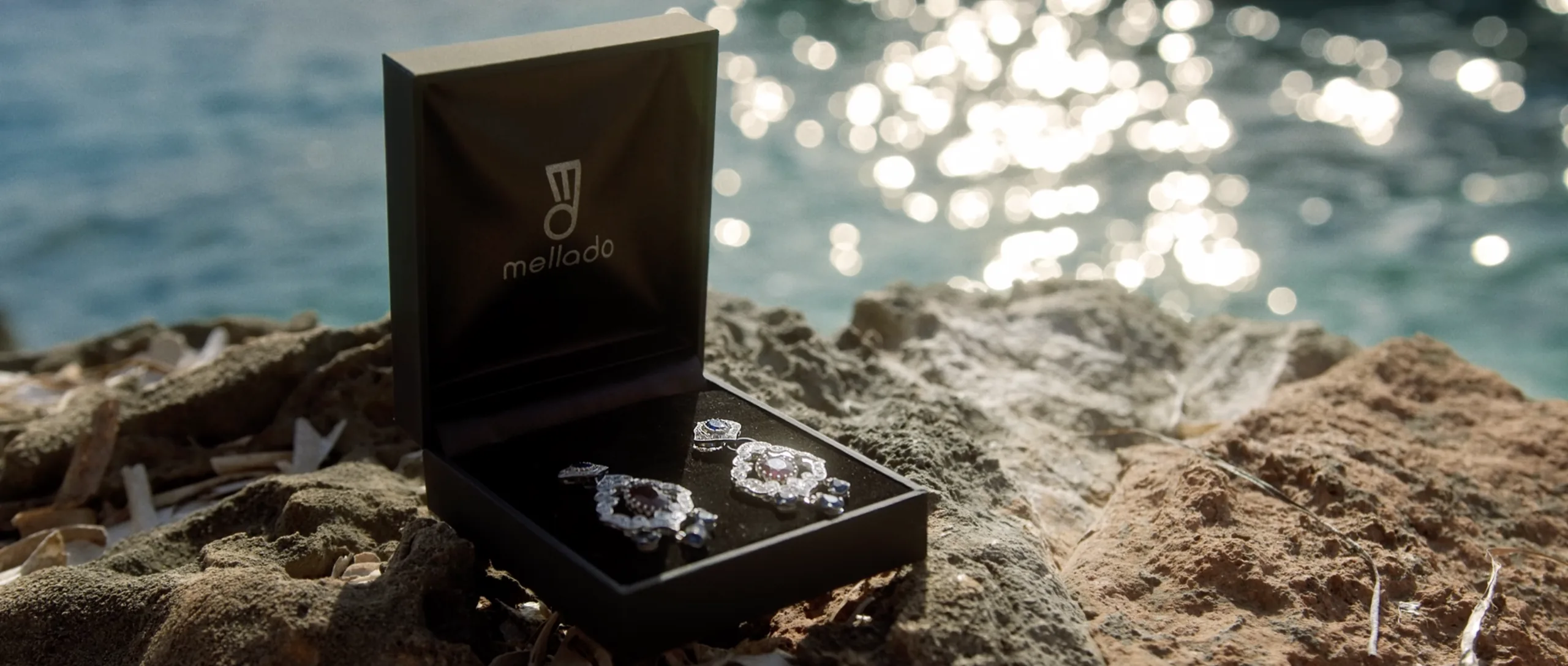 Estuche de Mellado con pendientes sobre una roca frente al mar